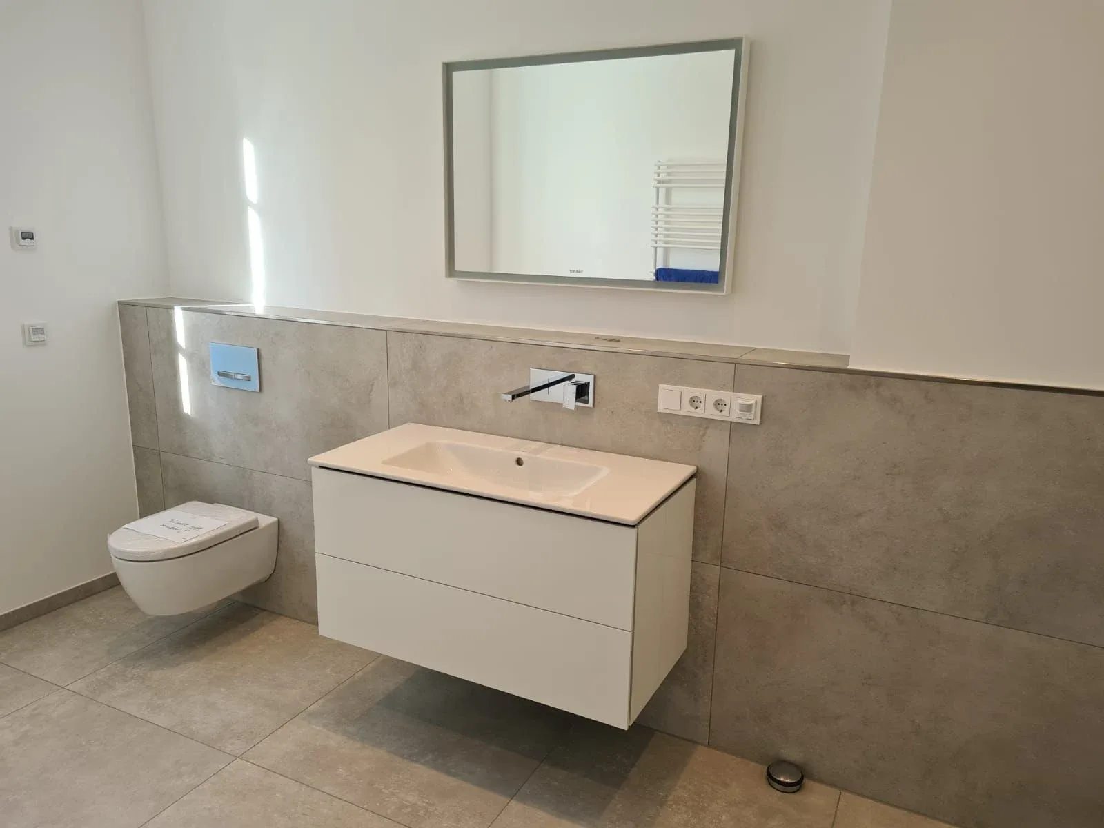 Beiges Badezimmer mit Waschtisch und Wand-WC