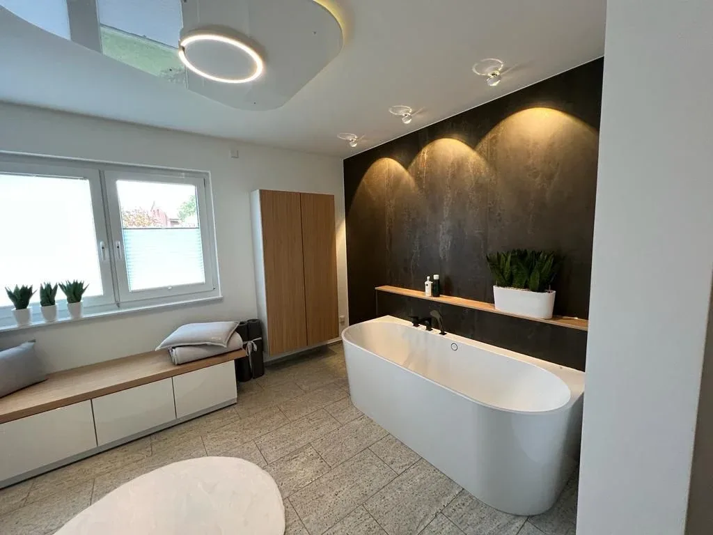 Badezimmer mit freistehender Wanne und Sauna