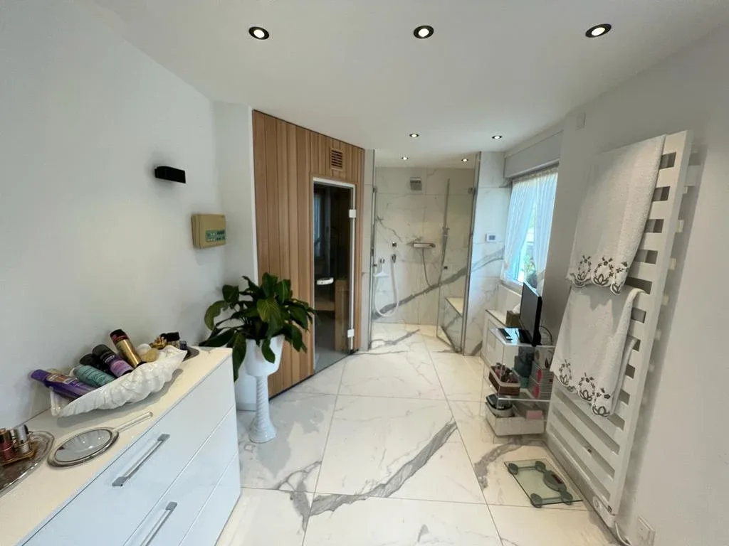 Helles Badezimmer mit Sauna und Glasabtrennung