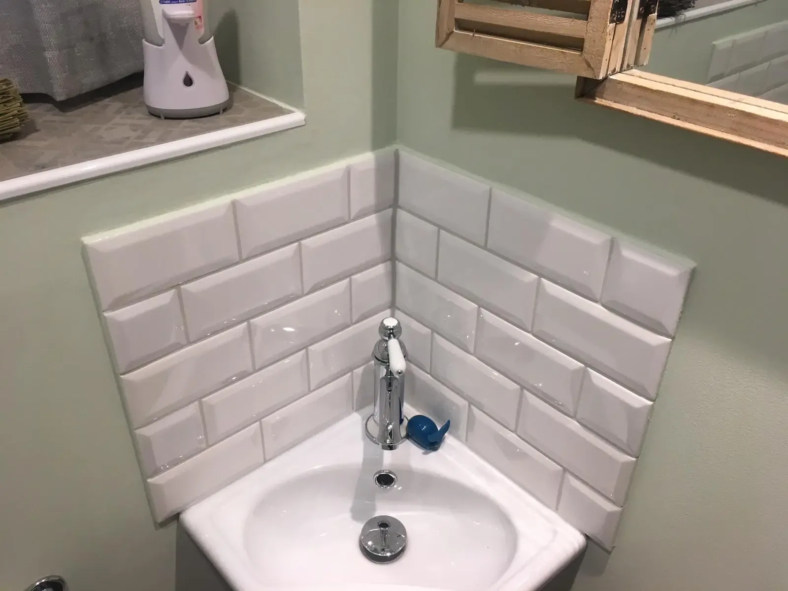 Gäste-WC mit Eckwaschbecken und weißen Metrofliesen
