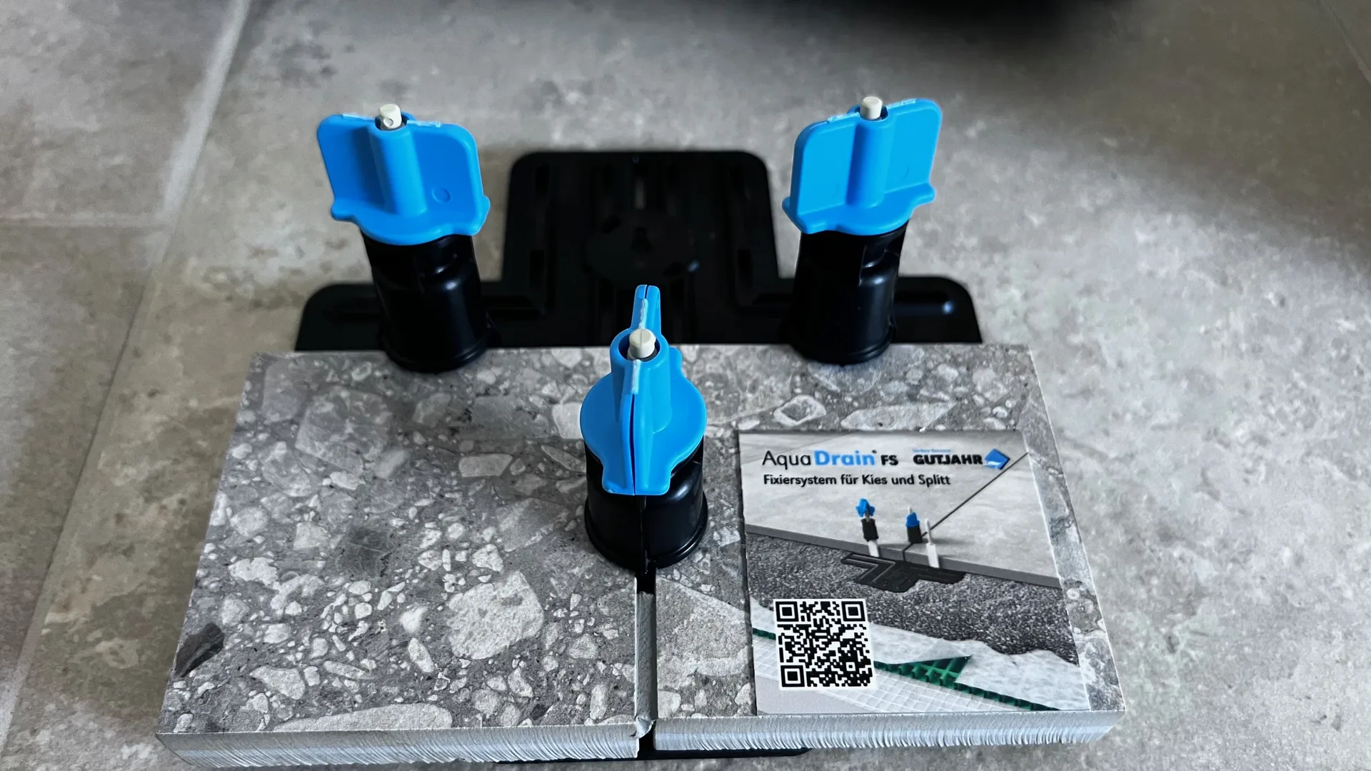 Blaue Nivellierhilfen an einer Fliesen-Musterplatte