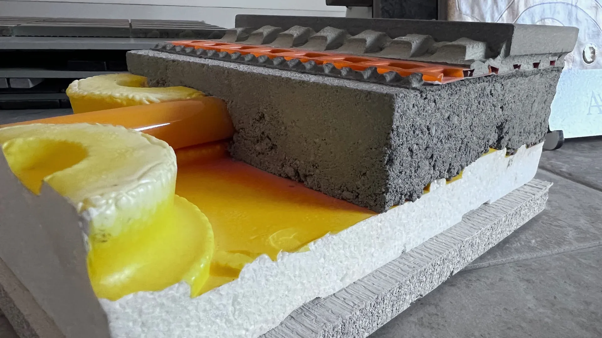 Schnittmodell eines Bodenaufbaus mit Rohrführung und Fliesenbelag