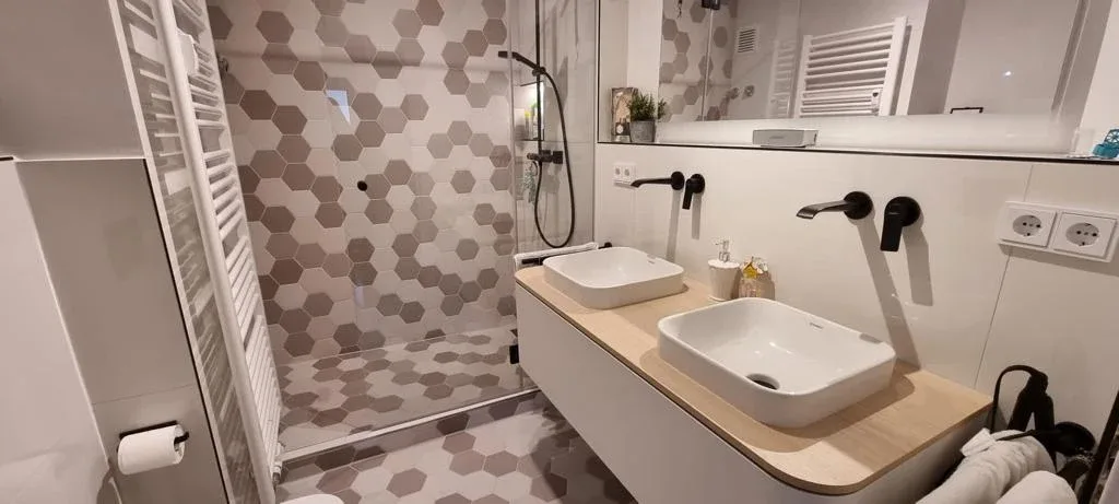 Badezimmer mit Hexagon-Dekor und Glasdusche