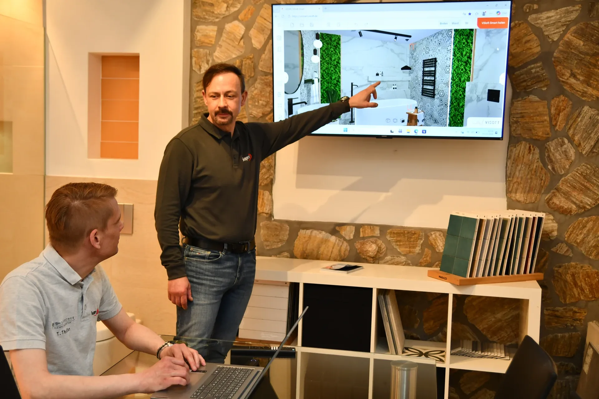 Besprechung eines 3D-Badentwurfs am Bildschirm in der Ausstellung Besprechung eines 3D-Badentwurfs am Bildschirm in der Ausstellung