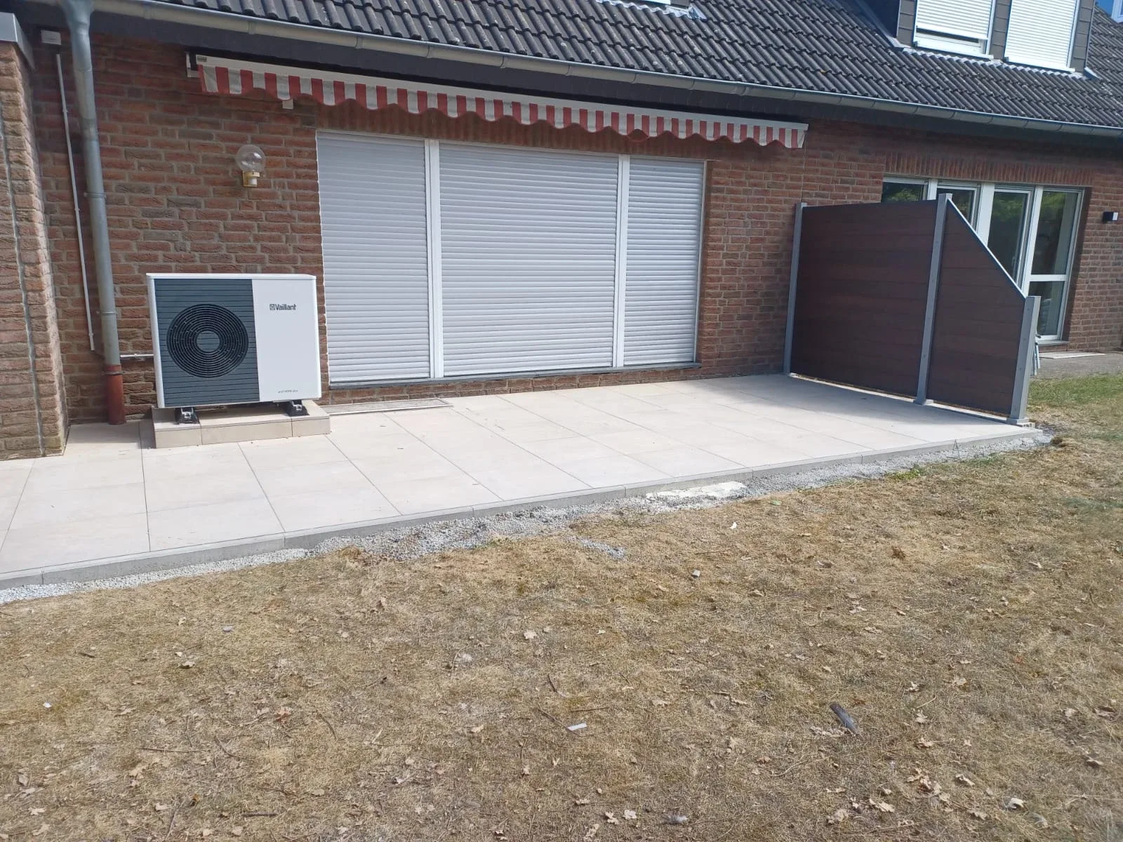 Terrassenbelag vor einer Klinkerfassade mit Gartenanschluss
