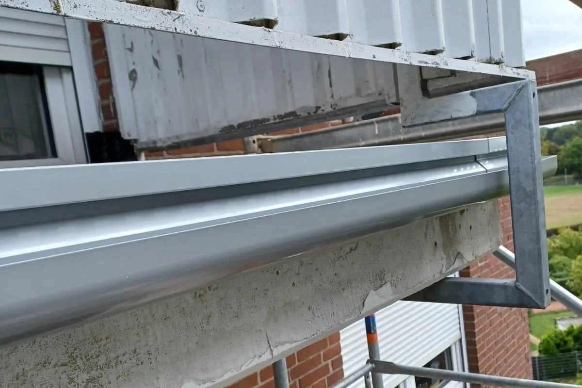 Neue Aluminium-Balkonrinne am Balkonrand in Jüchen, hinter den seitlichen Geländerhaltern